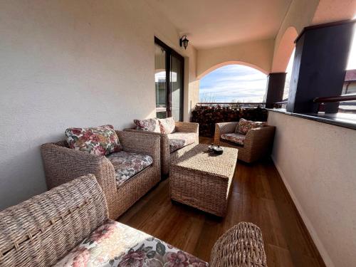 a living room with wicker furniture and a balcony at Entheos in Vŭrben