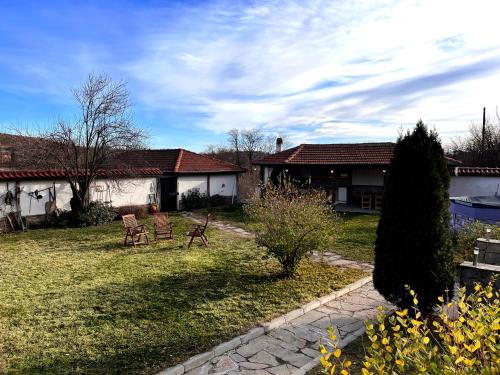 a yard with two chairs and a house at Entheos in Vŭrben