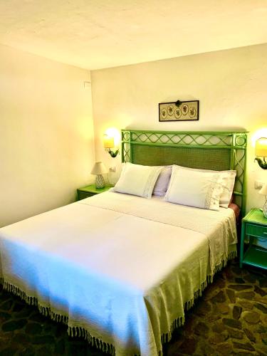 a hotel room with a large bed with white sheets at LA DEPENDANCE in Su Forti