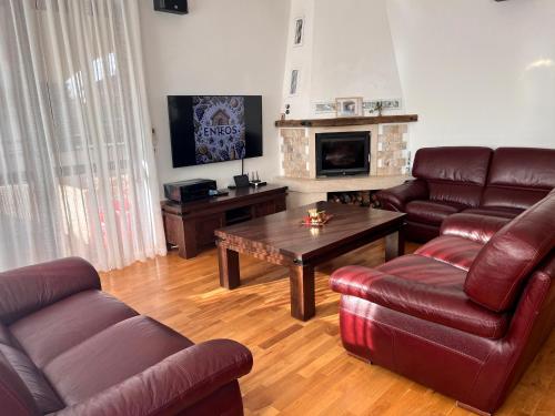 a living room with leather furniture and a fireplace at Entheos in Vŭrben