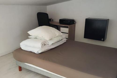 a room with a bed with three pillows and a tv at Superbe duplex de 64m2 - T2 proche Saclay in Les Ulis