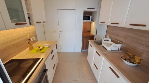 uma cozinha com armários brancos e uma tigela de fruta no balcão em Villa Stjepan em Zavala