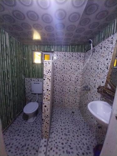 a bathroom with a toilet and a sink at Orange Beach hostel in Cape Coast