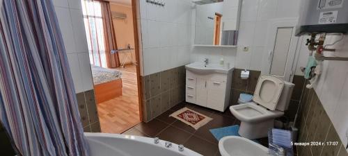 y baño con bañera, aseo y lavamanos. en ЖК БОТАНИКА en Aktau