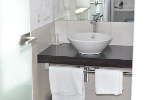 a bathroom with a sink and towels on a counter at Hotel Feyrer in Senden