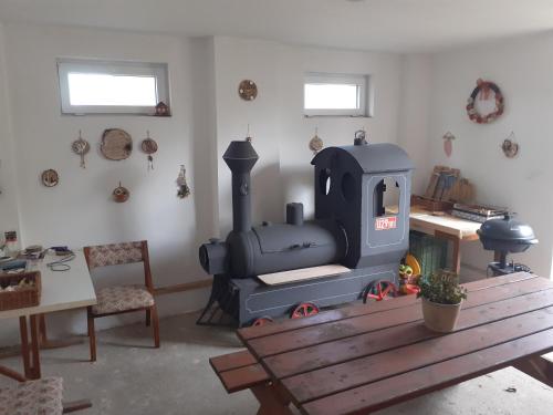 a room with a stove and a wooden table at Chalupa Kocourov in Slavíkov