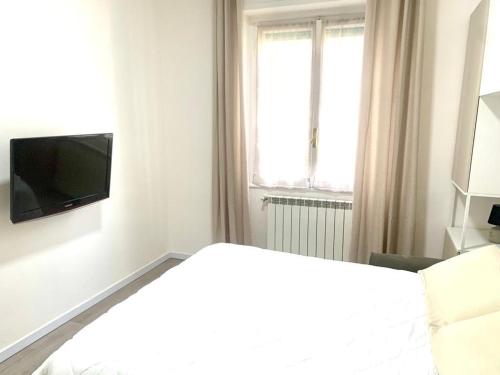 un salon blanc avec une télévision et un canapé dans l'établissement d.s house mare & sentieri, à Rapallo