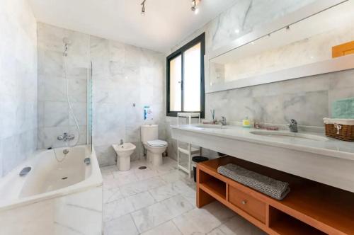 ein Badezimmer mit einer Badewanne, einem WC und einem Waschbecken in der Unterkunft Ático a 3 minutos de la Cala de Mijas in Mijas