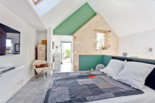 a bedroom with a large bed with a green headboard at La Ligne in Angles-sur-lʼAnglin