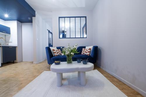 a living room with a blue couch and a table at Wisteria Villa - Rêves en soie, Ecully in Écully