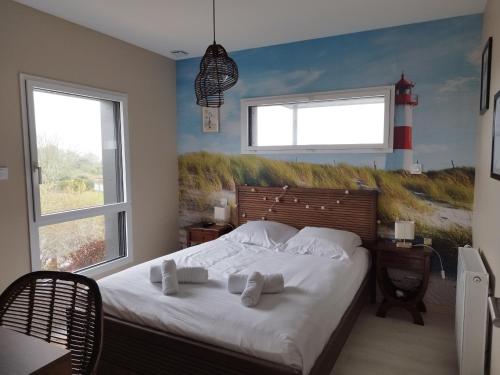 - une chambre avec un grand lit et 2 fenêtres dans l'établissement TY COAT - Maison neuve avec vue mer, piscine et bain nordique, à Saint-Pabu