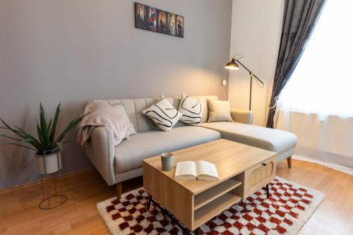 a living room with a couch and a coffee table at StadtNatur Apartment am Küchwald - mit Balkon, Streaming-TV, Badewanne, Arbeitsplatz in Chemnitz