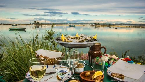 una mesa con vasos y un tazón de comida y agua en TY COAT - Maison neuve avec vue mer, piscine et bain nordique, en Saint-Pabu