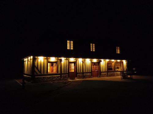 a building with lights on it at night at Augettes Longère normande in Saint-Hymer