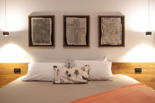 a bed with three framed pictures on the wall at Villas Mar y Coral in Puerto Viejo