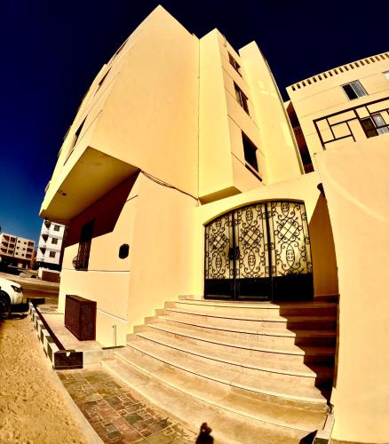 a building with stairs leading to a doorway with a door at comfort zone in Safaga 