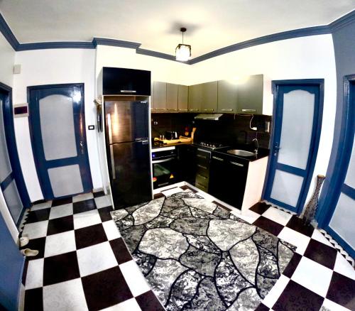 a kitchen with a black and white checkered floor at comfort zone in Safaga 