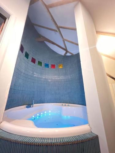 a bathroom with a blue tub in a room at Unique luxury self-contained oast apartment in Kent