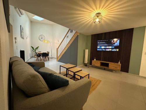 a living room with a couch and a flat screen tv at Le 58 - Loft Robespierre in Reims