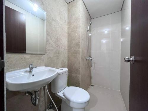 La salle de bains est pourvue de toilettes blanches et d'un lavabo. dans l'établissement Apt Transpark Cibubur 2 BR With Wi-Fi & Pool, à Kalimanggis