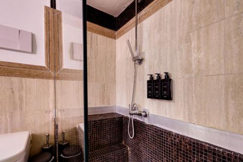 a bathroom with a glass shower with a toilet at Piazza Farnese Luxury Suites in Rome