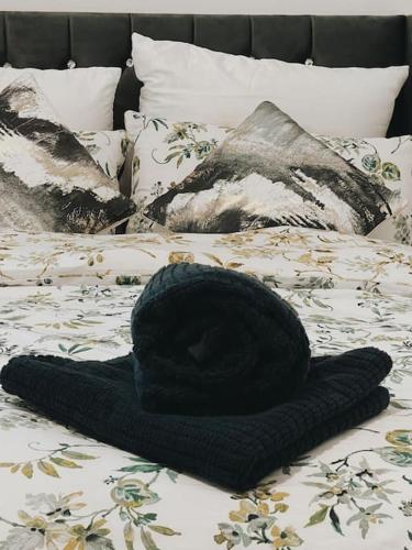 a black hat sitting on top of a bed at CentralGem Retreat 02 in Redditch