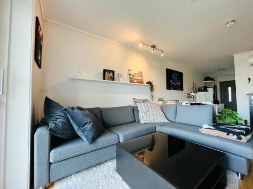 uma sala de estar com um sofá azul e uma mesa em 2 bedroom apartment in great location em Kristiansand