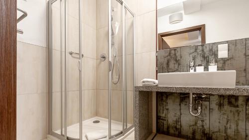 La salle de bains est pourvue d'une douche et d'un lavabo. dans l'établissement VacationClub – Royal Tulip Sand***** Apartament 431, à Kołobrzeg