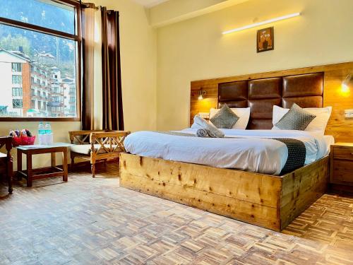 1 dormitorio con cama grande y ventana grande en The Kalinga Resort Manali - Heaven In Mountains en Manāli