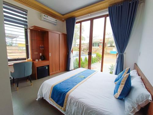 a bedroom with a bed and a desk and a window at Khe Sanh Luxury Hotel in Hương Hóa