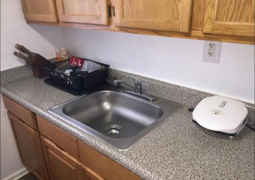 a kitchen counter with a sink and a cutting board at Suite 55 in Elmwood Park