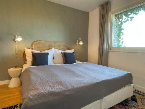 a bedroom with a large bed and a window at Villa Rebgärtle mit Seeblick in Bregenz