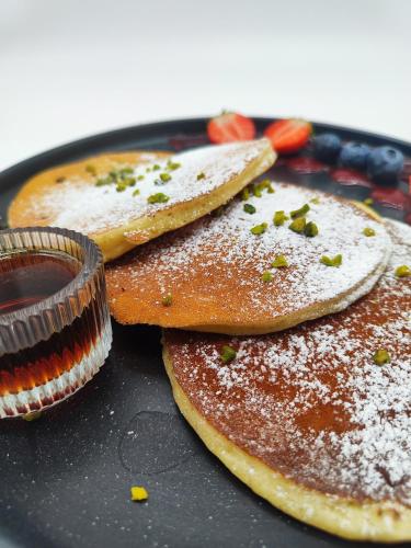 three pancakes on a black plate with a sauce at Boutique Hotel Kolbeck in Vienna