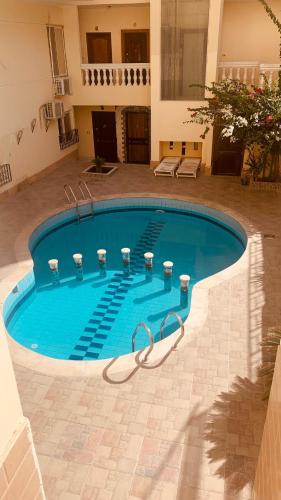 a large swimming pool in a courtyard with a building at comfort zone in Safaga 