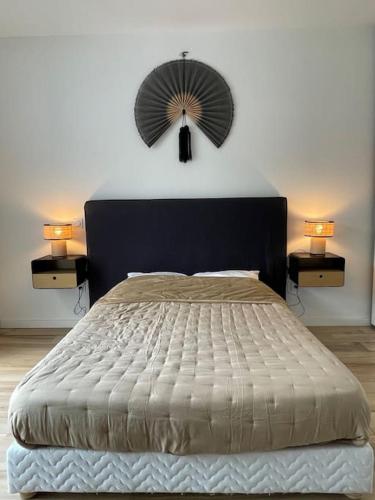 une chambre avec un lit avec une tête de lit noire et deux lampes dans l'établissement Magnifique Studio dans Résidence neuve, à Corte