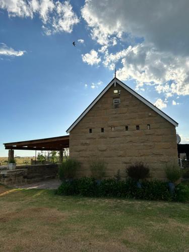 een grote bakstenen schuur met een bewolkte lucht op de achtergrond bij Eittel Guest Farm Cottage in Winburg