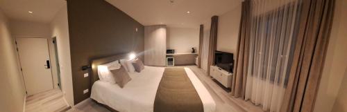 een grote slaapkamer met een groot wit bed in een kamer bij Den Ommegang in Halle