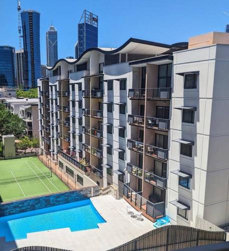 an apartment building with a tennis court and a tennis court at City & lakeside with free secure allocated parking, pool, gym & tennis court, only 15 mins walk into the City in Perth