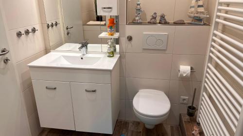 ein kleines Bad mit WC und Waschbecken in der Unterkunft Ferienhaus Wilhelmshaven Voslapp 78 in Wilhelmshaven