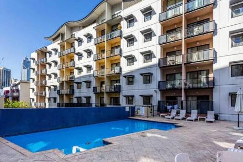 Un edificio de apartamentos con piscina enfrente. en City & lakeside with pool, gym & tennis court, only 15 mins walk into the City, en Perth