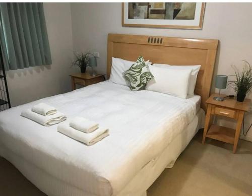 a bedroom with a large white bed with towels on it at City & lakeside with free secure allocated parking, pool, gym & tennis court, only 15 mins walk into the City in Perth