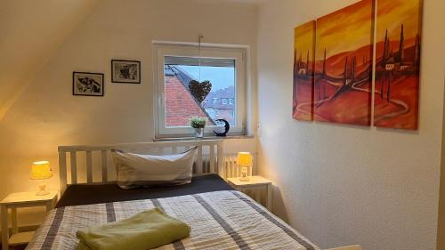 a bedroom with a bed and a window at Ferienhaus Wilhelmshaven Voslapp 78 in Wilhelmshaven