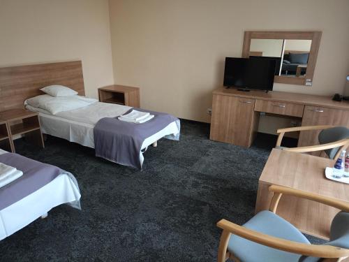 um quarto de hotel com duas camas e uma televisão de ecrã plano em Hotel Olimpijski em Oświecim