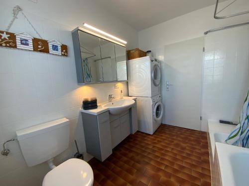 a bathroom with a toilet sink and a washing machine at Sunny apartment in Pähl in Pähl