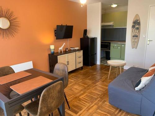 un salon avec une table et un canapé et une cuisine dans l'établissement Appartement à 2 pas de la mer, à Berck-sur-Mer