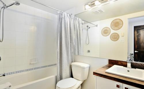 een witte badkamer met een toilet en een wastafel bij 26#22 Chemin du Hameau in Stoneham