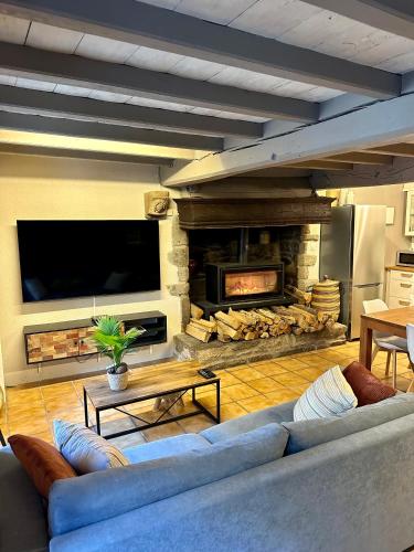 a living room with a blue couch and a fireplace at L'abri-côtier in Saint-Suliac
