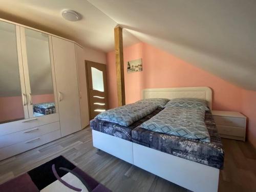ein Schlafzimmer mit einem Bett und einer Kommode in der Unterkunft Krušnohorský apartmán in Kraslice