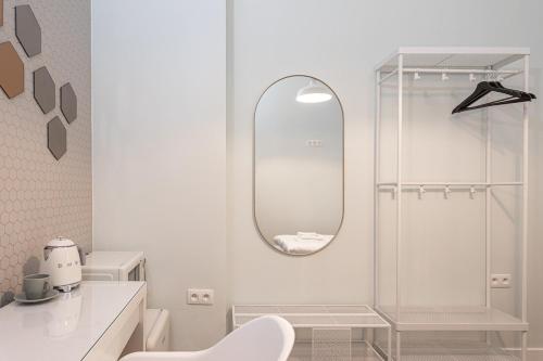 a white bathroom with a shower and a mirror at Van Lerius singleroom in Antwerp