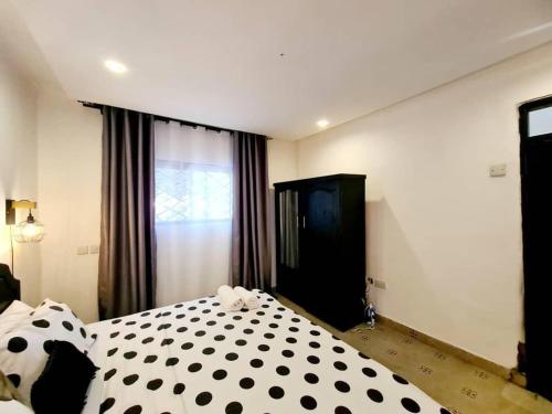 a bedroom with a black and white polka dot bed at Retreat Homes in Dar es Salaam